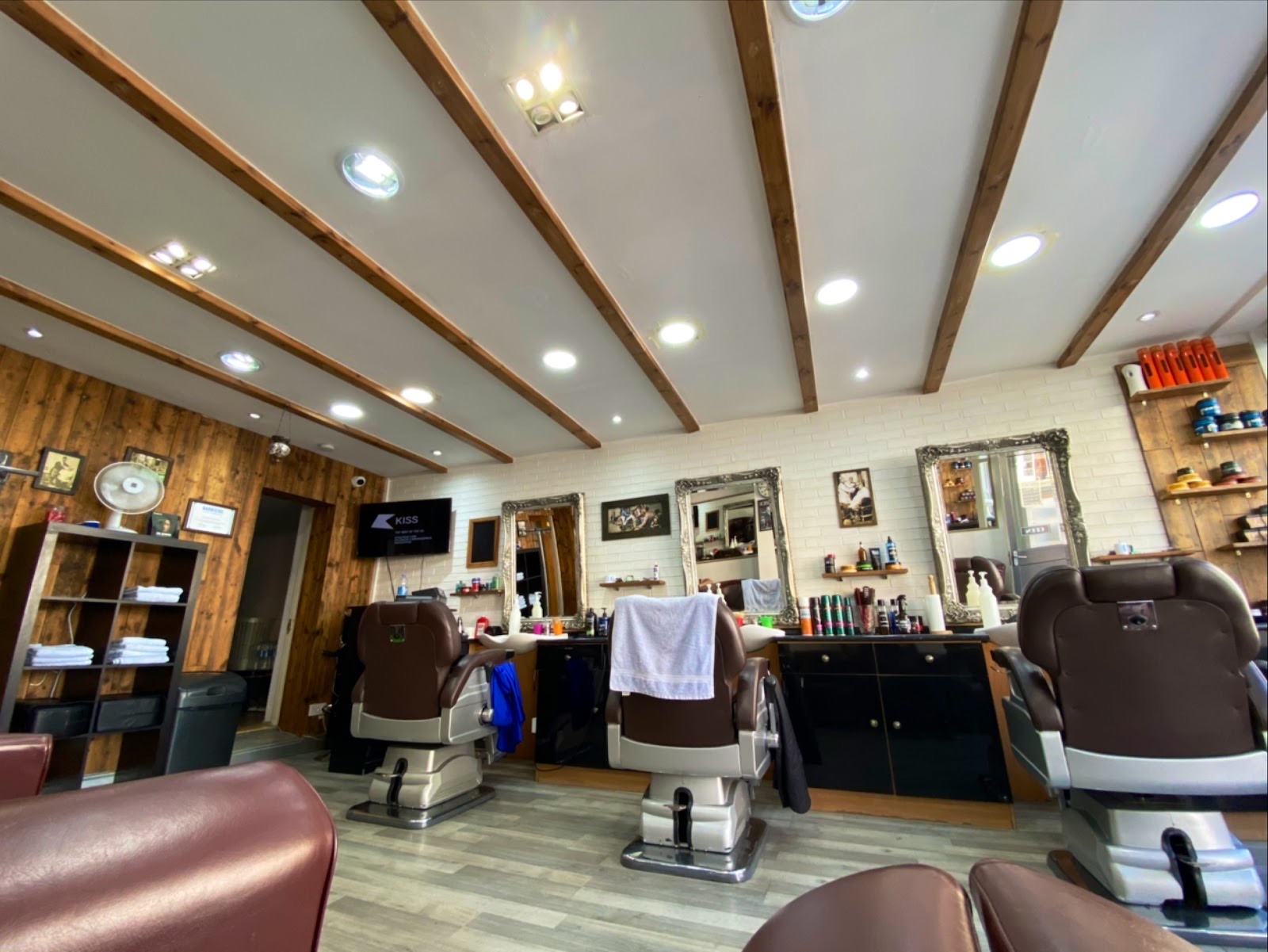 Inside Cutt Throat barbershop on Hoxton Street: traditional chrome barber chairs, ornate silver mirrors, white brick and warm wood panelling